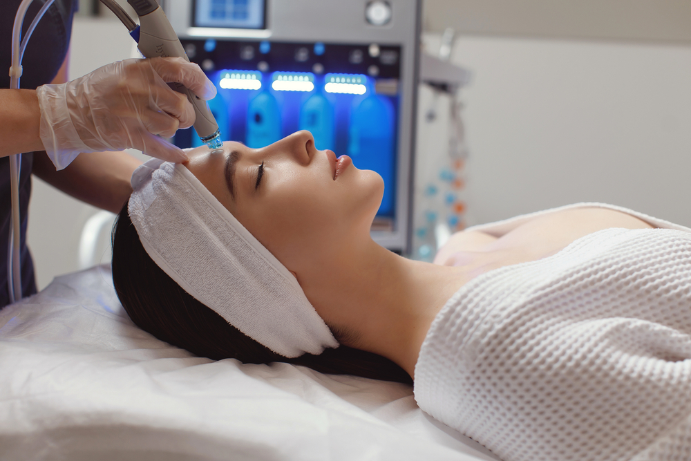 Side,View,Of,Woman,Receiving,Microdermabrasion,Therapy,On,Forehead,At